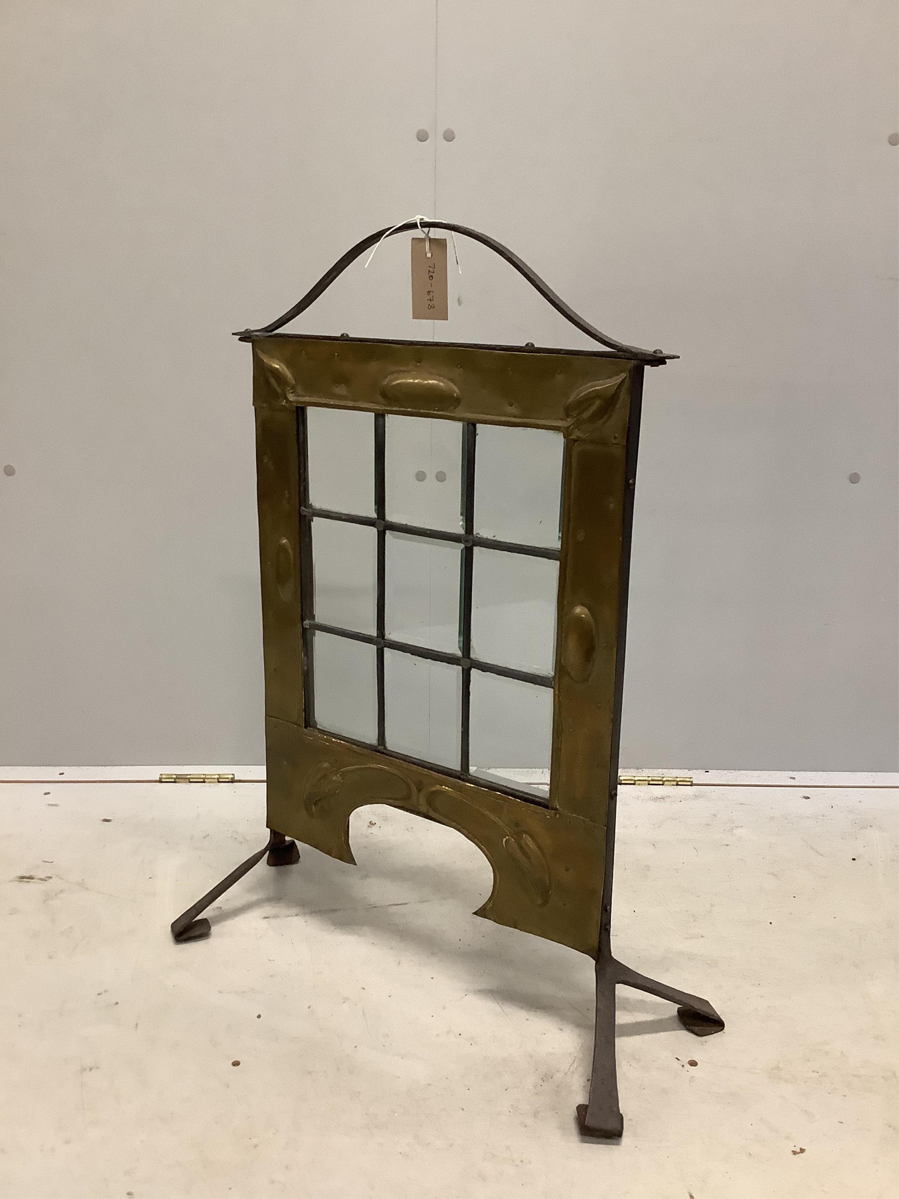 An Arts & Crafts glazed brass and wrought iron firescreen, width 60cm, height 77cm. Condition - fair to good